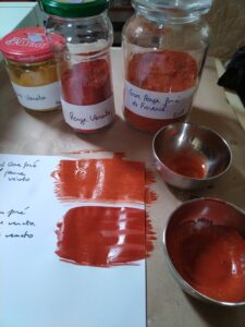 Préparation de peintures à partir de pigments bruts, avec des échantillons de couleurs rouges et ocres. Matériaux pour la fabrication de peinture artisanale naturelle à la tempéra.